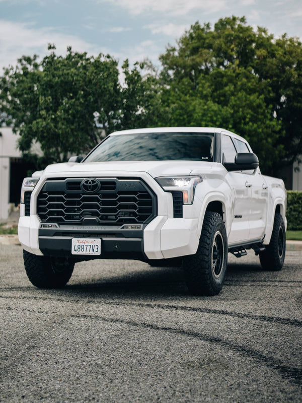 White Toyota Tundra TRD Off-Road with Method Race Wheels and BFGoodrich all-terrain tires, front three-quarter view, upgraded by Empire Motorsports & LINE-X in Rancho Cucamonga