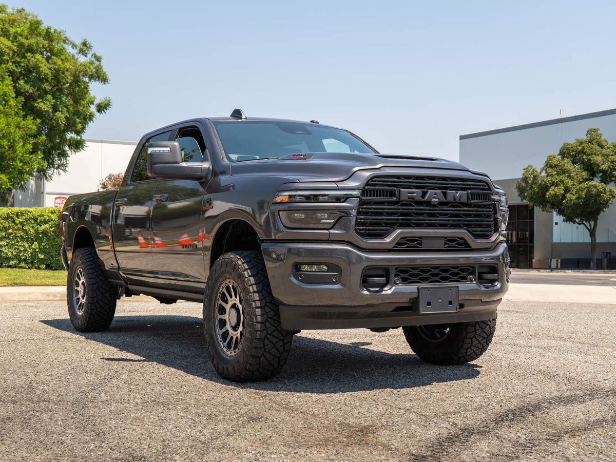Front three-quarter view of a lifted gray 2025 RAM Heavy Duty with King shocks and Method wheels, built by Empire Motorsports & LINE-X in Rancho Cucamonga