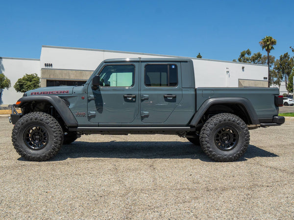 Side profile of a gray Jeep Gladiator Rubicon with a TeraFlex lift and black Method wheels, built by Empire Motorsports & LINE-X in Rancho Cucamonga