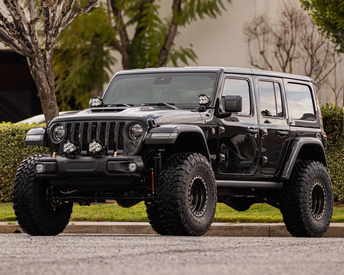 Front three-quarter view of a lifted black Jeep Wrangler Rubicon on black wheels