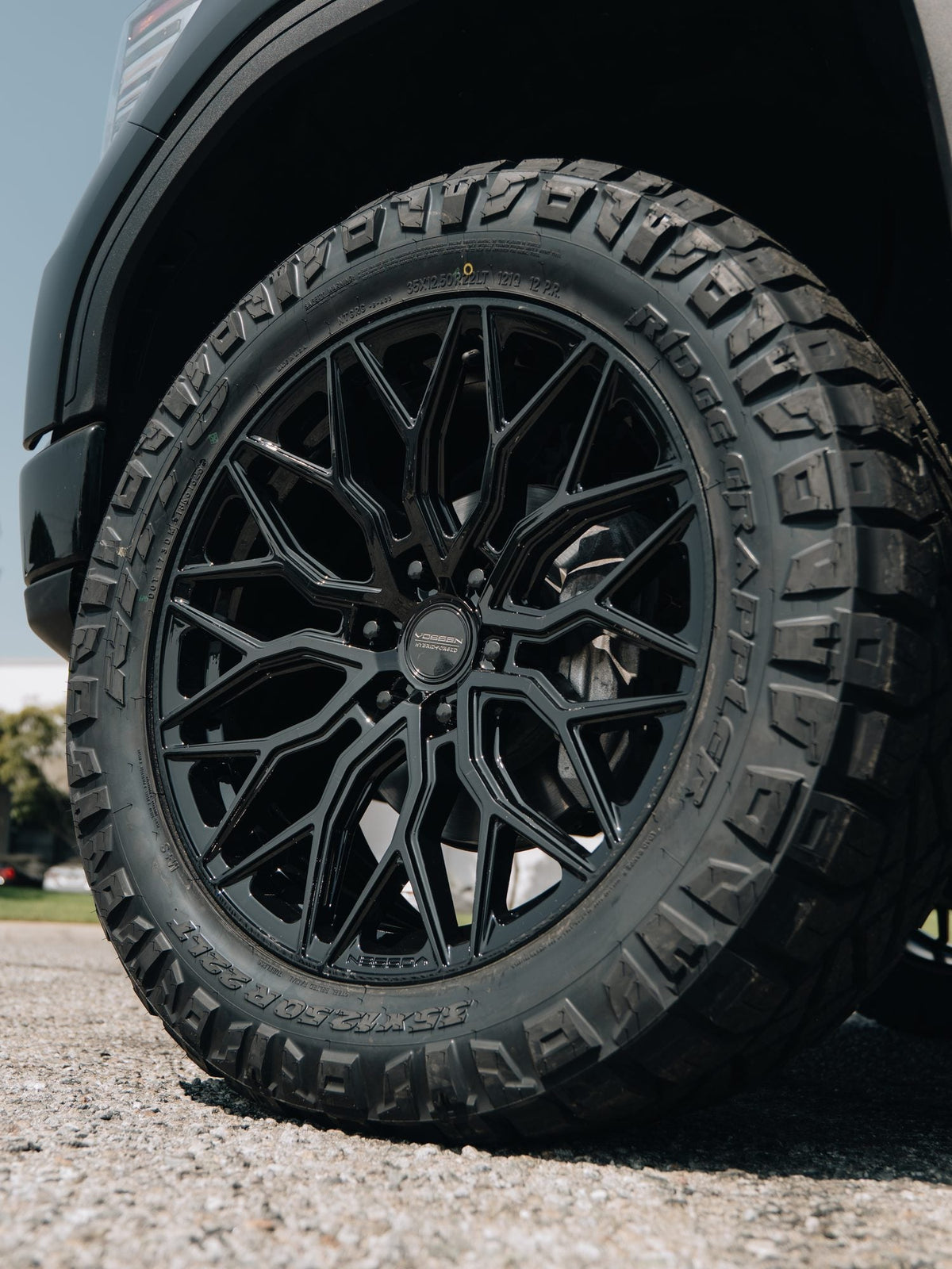 Close-up of a black Vossen wheel with a Nitto Ridge Grappler tire on a GMC Sierra 1500 Denali built by Empire Motorsports & LINE-X in Rancho Cucamonga