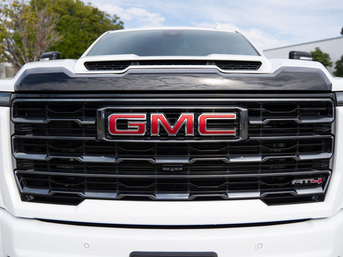 Close-up of the front grille and GMC logo on a white Sierra 2500 HD AT4