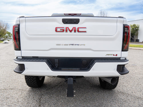 Rear view of a white GMC Sierra 2500 HD AT4 tailgate with GMC lettering