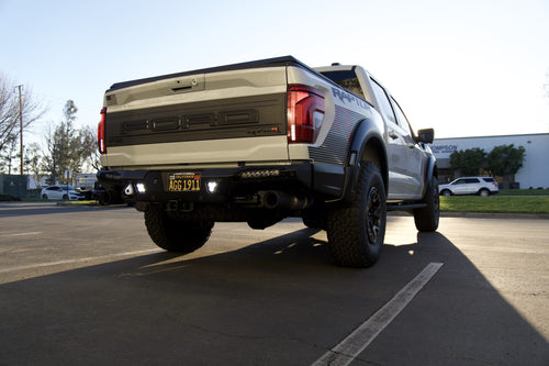 Low rear three-quarter view of a Ford F-150 Raptor R with the sun behind it