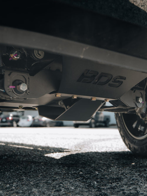 Underside view of a BDS lift kit crossmember skid plate on a GMC Sierra