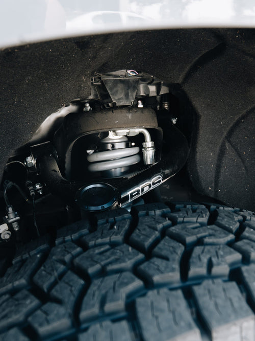 BDS suspension lift and coilover in the front wheel well of a white truck
