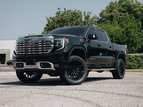 Front three-quarter view of a black GMC Sierra Denali with a BDS lift and Vossen wheels