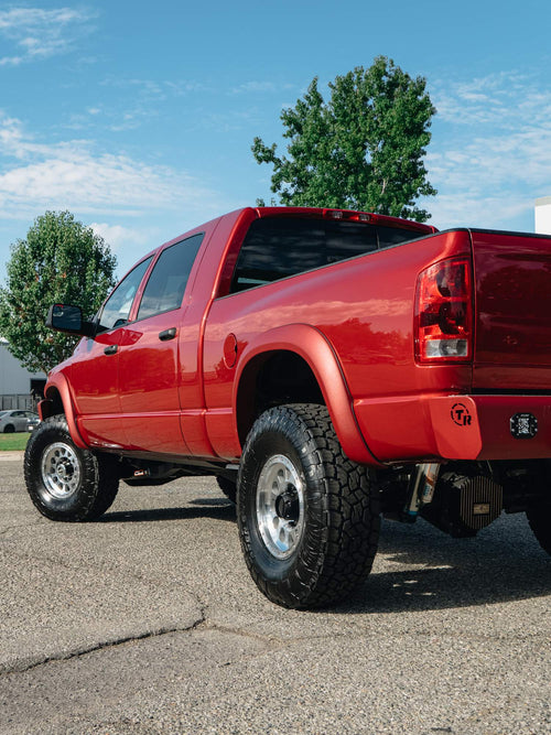 Rear three-quarter view of a lifted red Dodge Ram HD with Carli suspension
