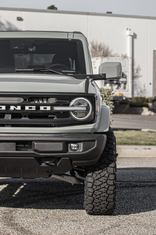 Front fascia of a gray Ford Bronco with an aggressive off-road tire