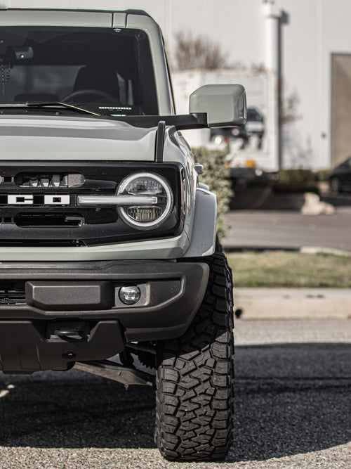 Headlight and bumper of a gray Ford Bronco