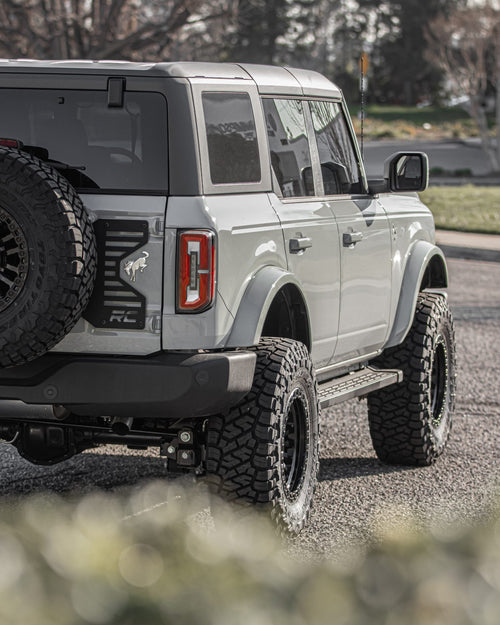 Rear corner of a gray Ford Bronco showing the taillight and spare tire