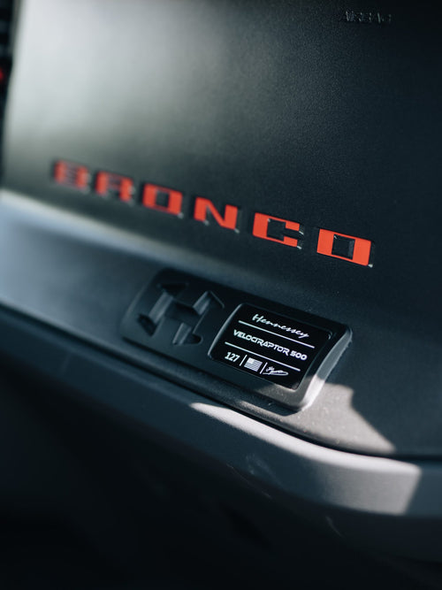 Red BRONCO lettering on the interior trim of a blue Ford Bronco Raptor