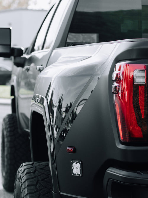 Rear bed side and taillight of a gray Ford F-150 Lightning with a black graphic accent