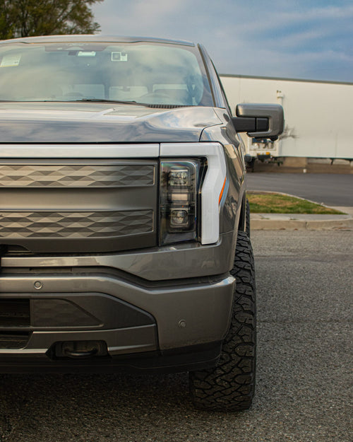 Front fascia and headlight of a gray Ford F-150 Lightning