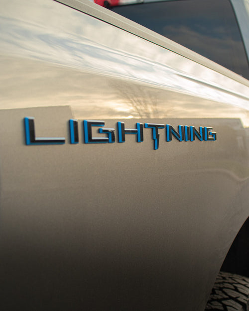 LIGHTNING badge on the fender of a gray Ford F-150 Lightning