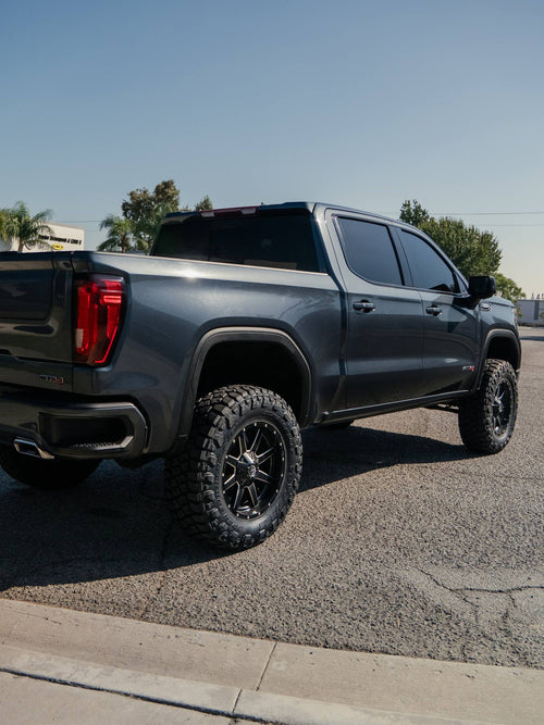 Rear three-quarter view of a gray GMC Sierra 1500 AT4 with a BDS lift and Nitto Ridge Grappler tires