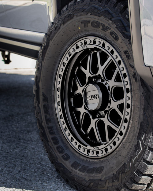 Side view of a black wheel and tire on a silver GMC Sierra HD AT4