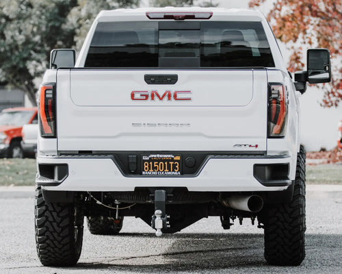 Rear view of a lifted white GMC Sierra 2500 HD AT4 with GMC lettering on the tailgate