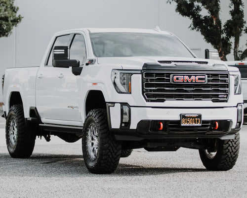 Front three-quarter view of a lifted white GMC Sierra 2500 HD