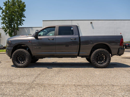 Side profile of a lifted gray Ram HD on black Method wheels