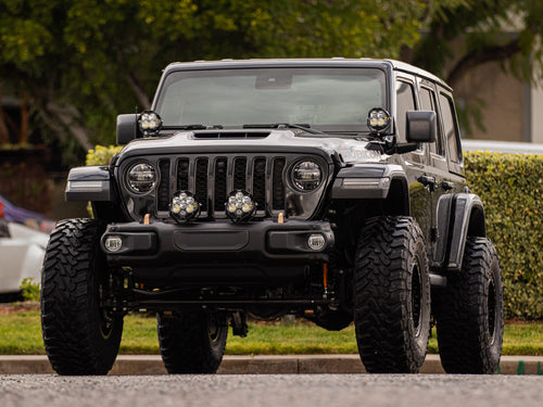 Head-on front view of a black Jeep Wrangler Rubicon with bumper-mounted lights