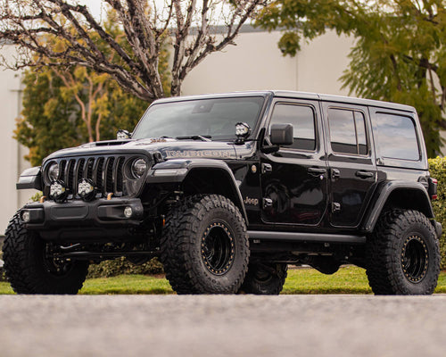 Side three-quarter view of a black Jeep Wrangler Rubicon parked on a street