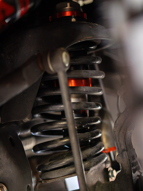 Coil spring and orange-accented shock on a lifted Jeep Wrangler Rubicon