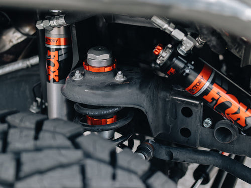 FOX Factory shocks with reservoir and orange accents on a gray Jeep Wrangler Rubicon