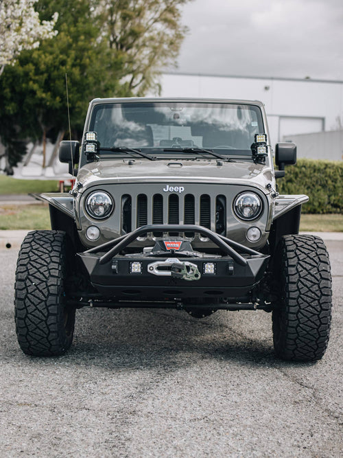 Head-on front view of a lifted gray Jeep Wrangler Rubicon with winch bumper