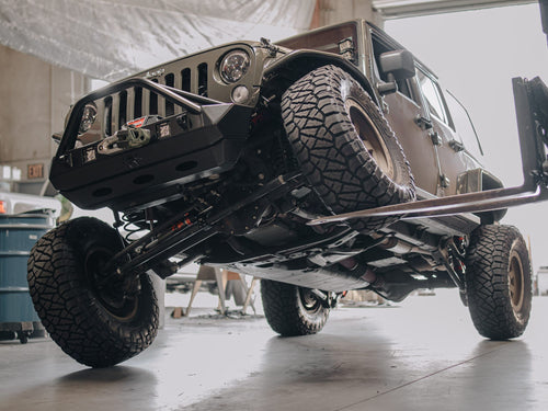 Lifted Jeep Wrangler with black wheels and a winch bumper