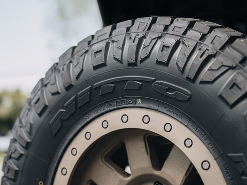 Nitto Ridge Grappler tire sidewall and bronze wheel on a gray Jeep Wrangler Rubicon