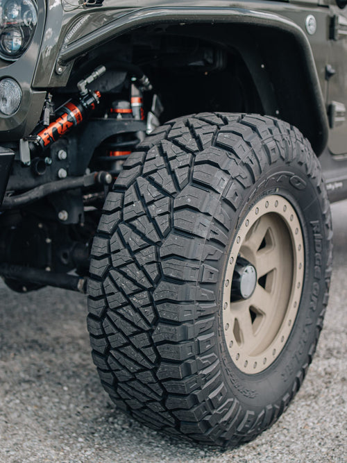 Shock and coil spring beside an off-road tire on a Jeep Wrangler Rubicon