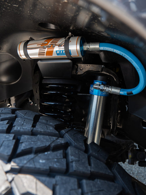 Close-up of a King remote reservoir shock with blue lines above the tire on a Ram HD