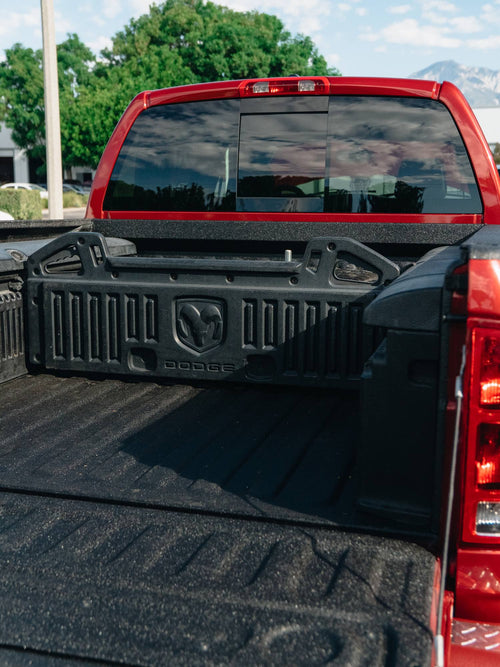 Truck bed of a red Ram HD with a LINE-X bedliner and Mopar bed divider