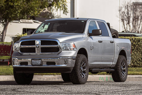 Silver RAM 1500 crew cab parked in front of a building