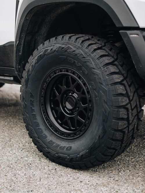 Close-up of a black Fuel Off-Road wheel with a Toyo tire on a white RAM 1500 TRX