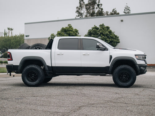 Side profile of a white RAM 1500 TRX with black Fuel wheels and Toyo tires