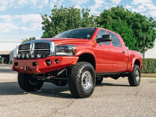 Front three-quarter view of a red Dodge Ram HD with a lighting and recovery build